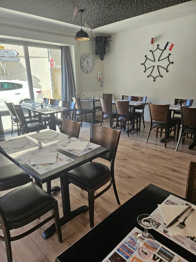 La salle de L'Ardoise Occitane, tables dressées et croix occitane au mur du fond